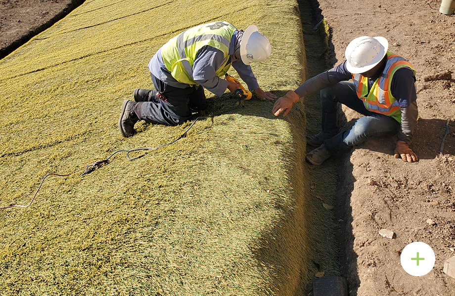 contractors lining slope with hydroturf